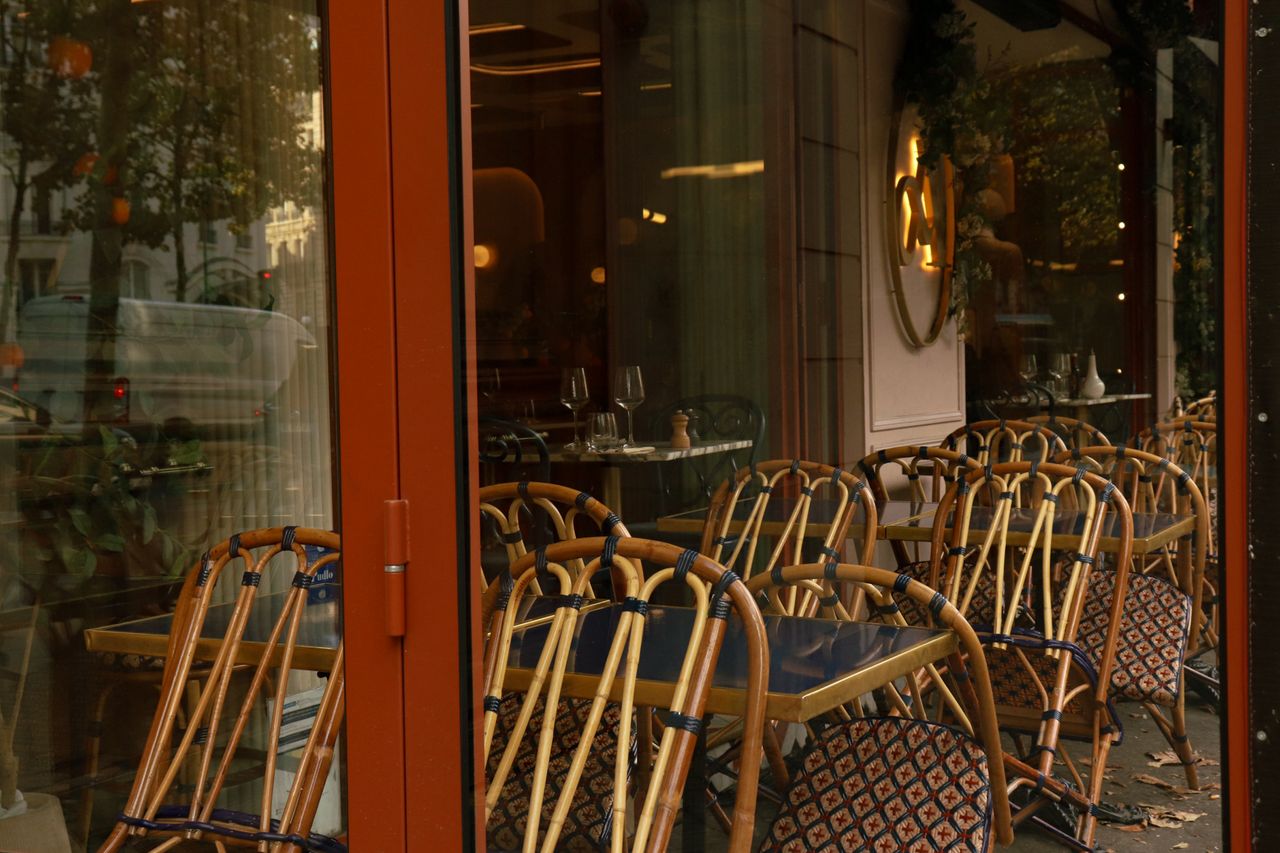 Cozy outdoor cafe with elegant wicker chairs and tables, perfect for a relaxing ambiance.