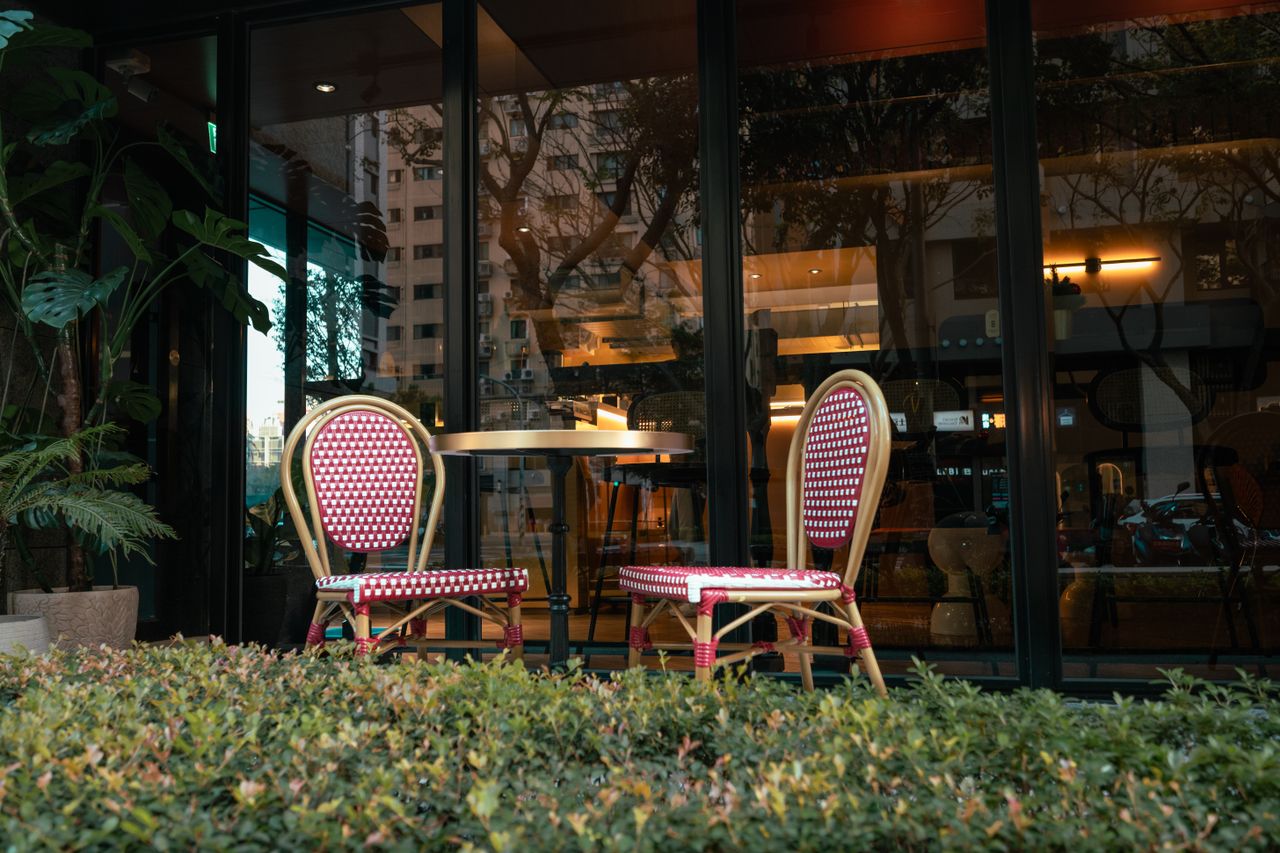 Charming outdoor seating with colorful chairs at a modern cafe, inviting for a coffee break.