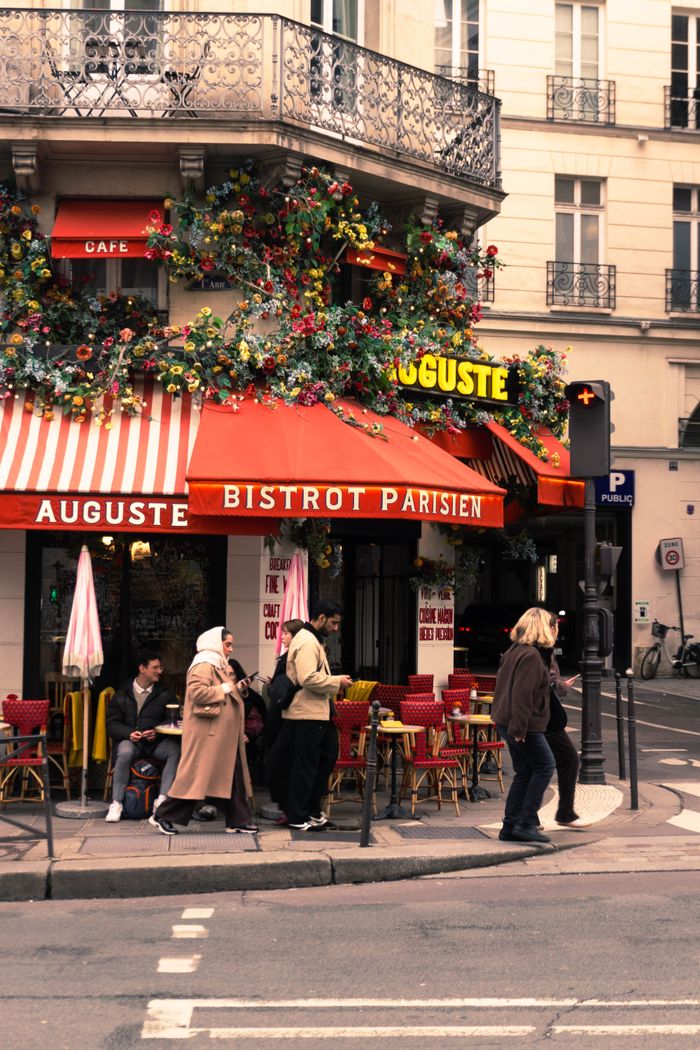 A lively Parisian street with people outside a quaint bistro in Paris.